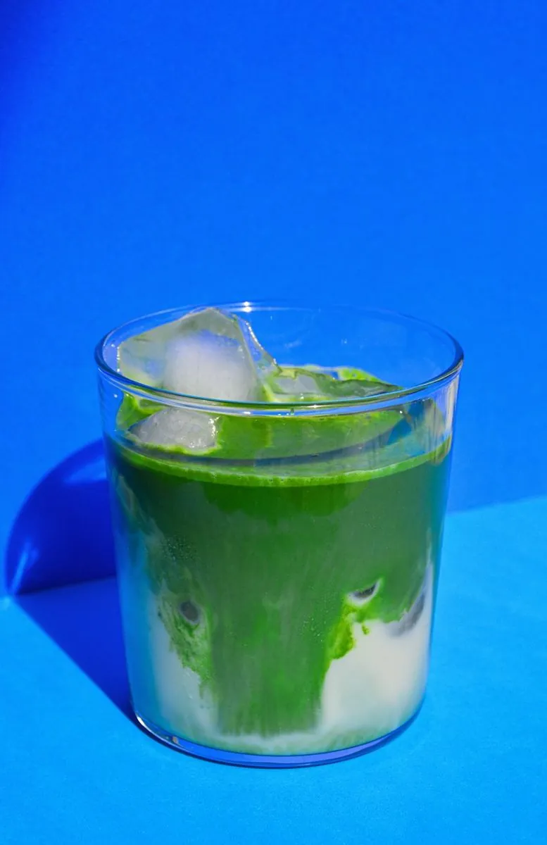 Verre de Deep Green glacé avec des glaçons, sur fond bleu